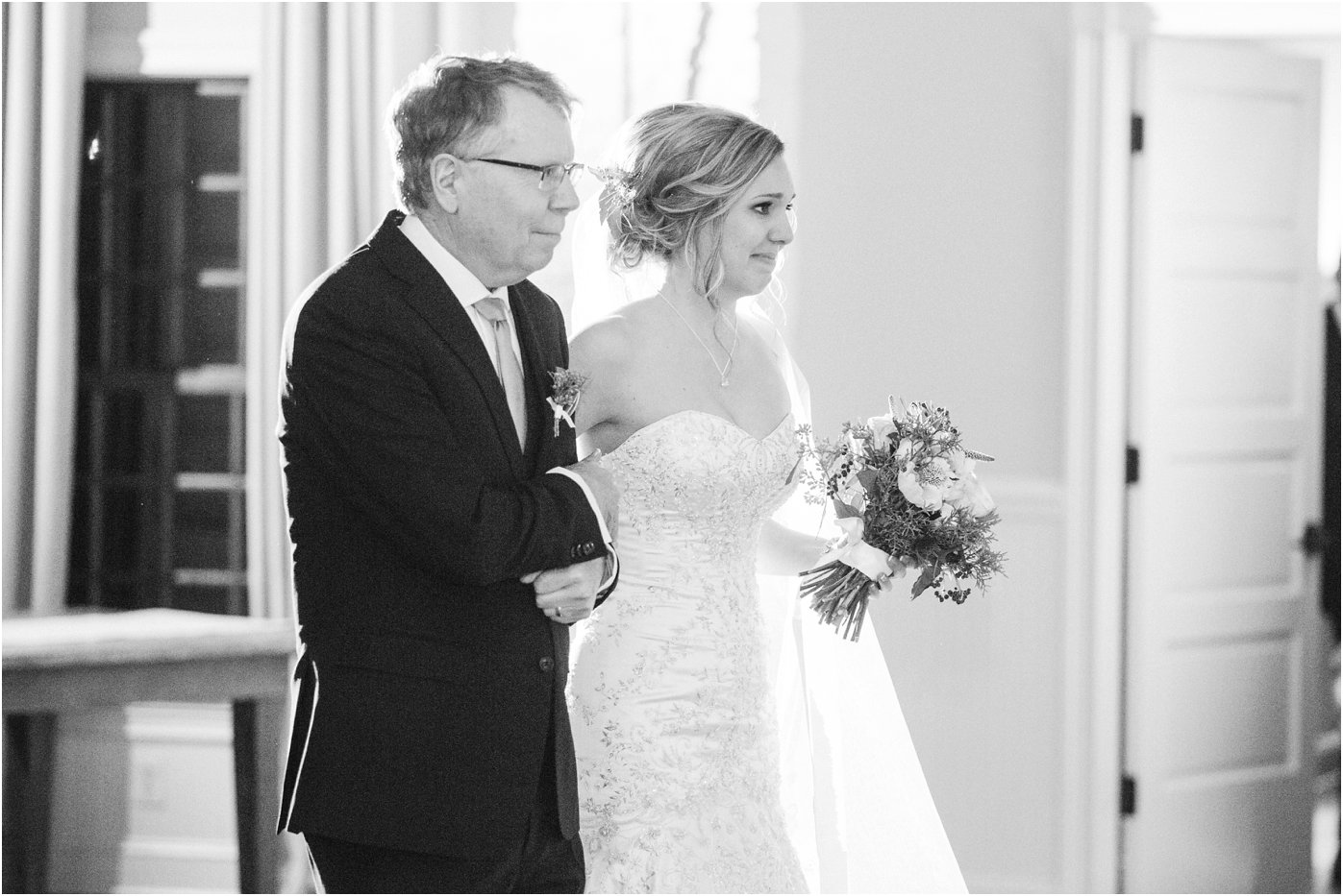emotional-bride-walks-down-the-aisle-with-her-father-by-her-side-in-the-reception-hall-at-early-mountain-vineyard