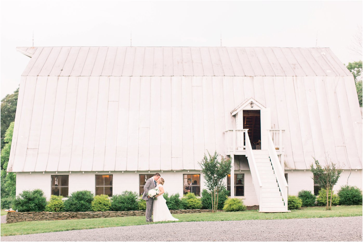 A bride and groom sharing a kiss in front of the 48 Fields Barn, a wedding venue in Leesburg, Virginia!