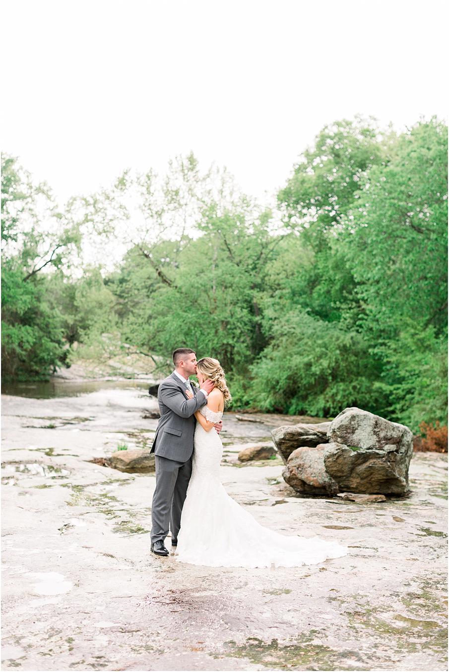Bride and groom sharing a moment on the rocks at the Mill at Fine Creek