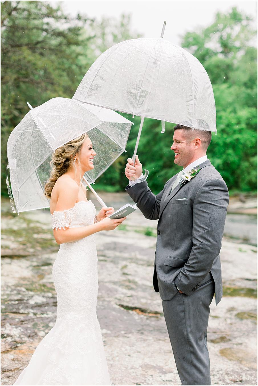 Bride and groom reading vows to one another in the rain after their first look at The Mill at Fine Creek
