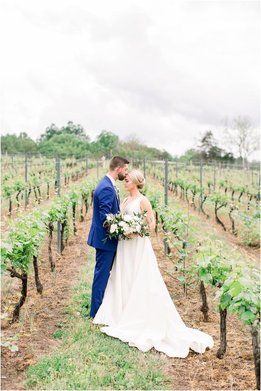 Bride and groom sharing a moment in the grape vines at their Morais Vineyards Wedding