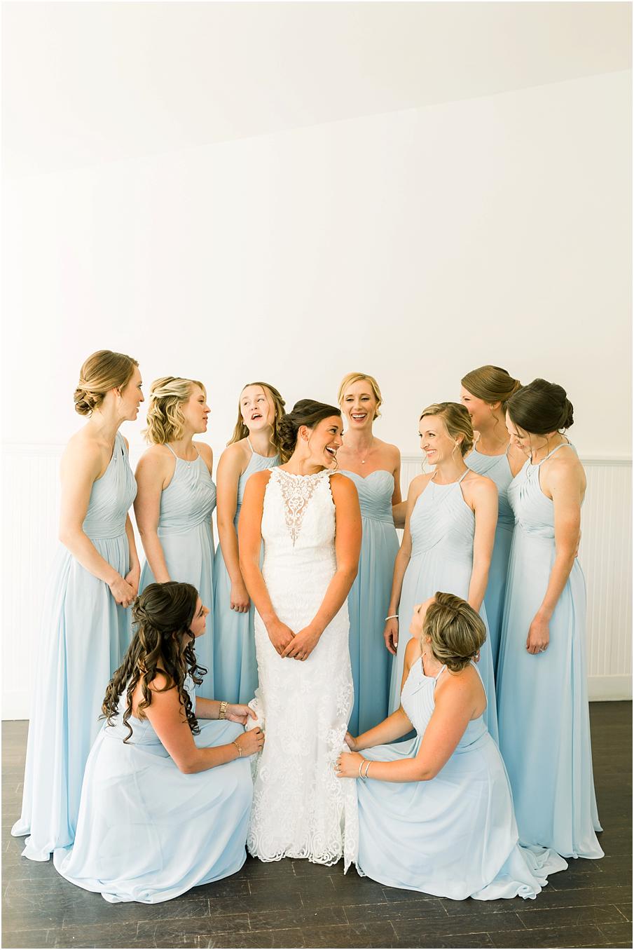 Bride in her stunning lace wedding gown, bridesmaids in sky blue dresses getting bride ready to see her groom at Veritas Winery.