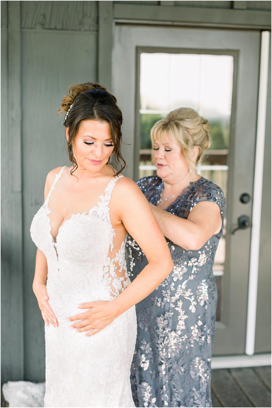 Mom buttoning bride's dress in Bluemont Vineyard's bridal suite before Bluemont Vineyard Wedding Day