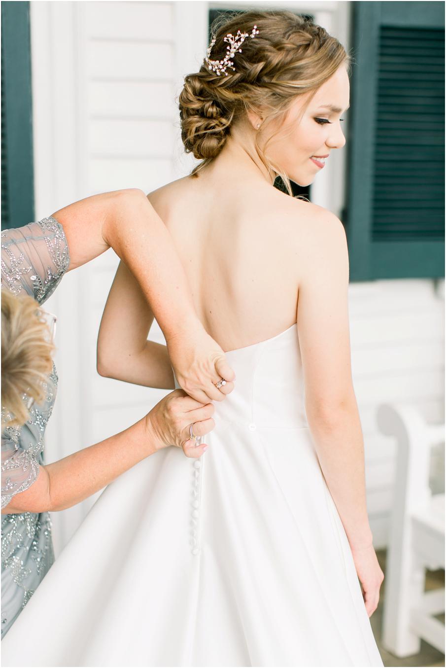 Mom buttoning up her daughter's wedding dress on a porch for her Pharsalia wedding day