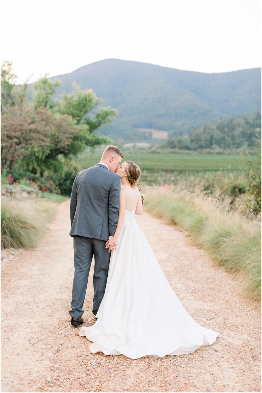 Bride and groom wedding portrait with a gravel road, mountain backdrop and beautiful florals. Pharsalia is one of the best mountain wedding venues in Virginia
