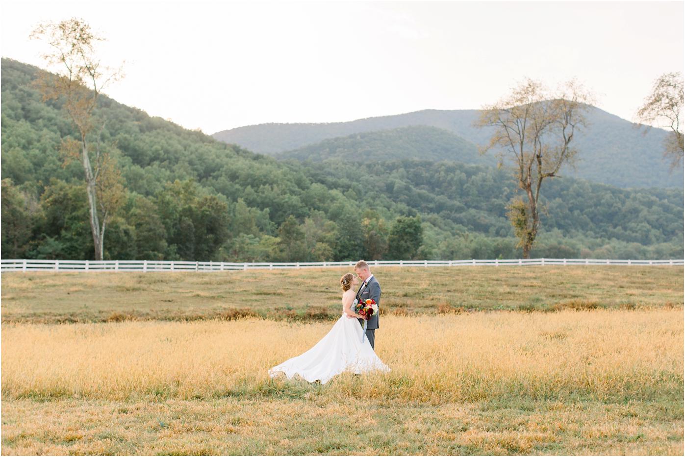 Bride and groom wedding portrait in a field with a mountain backdrop during their Pharsalia wedding day